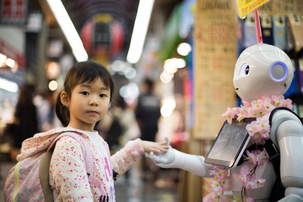 Une petite fille donne la main à un robot
